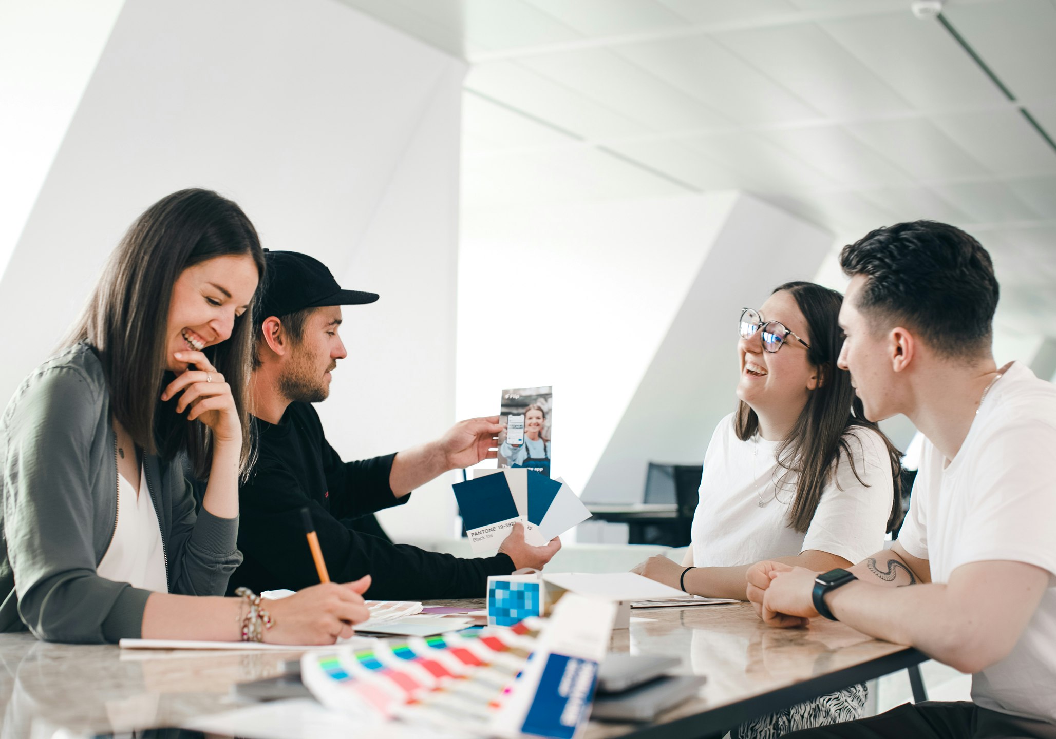 Four people laughing at a table during a workshop