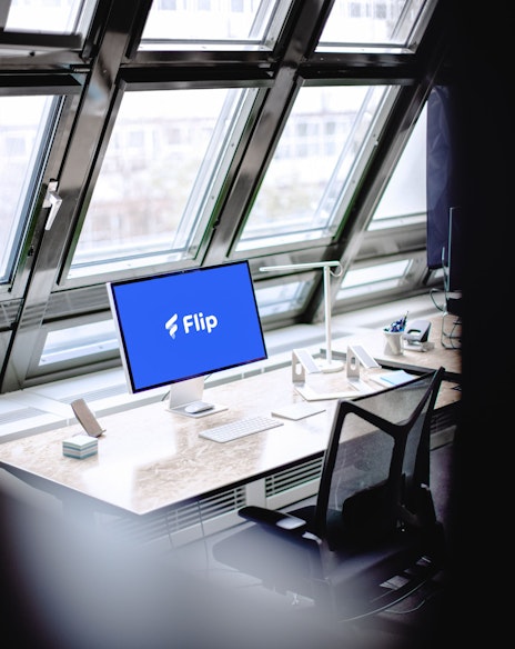 Desk with a screeSchreibtisch mit einem Bildschirm vor einem großen Fenstern in front of a big window