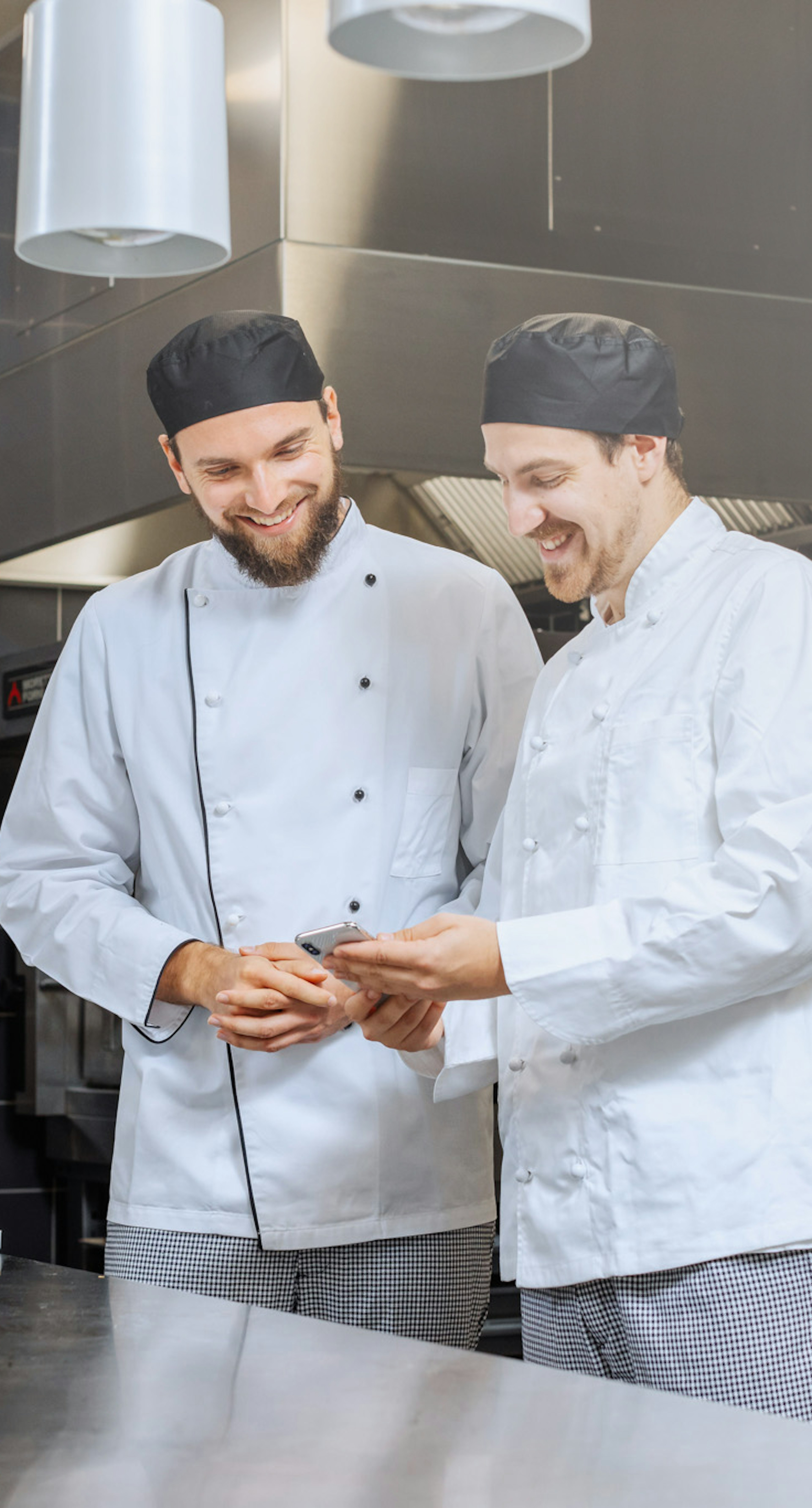 Two cooks looking at a mobile phone