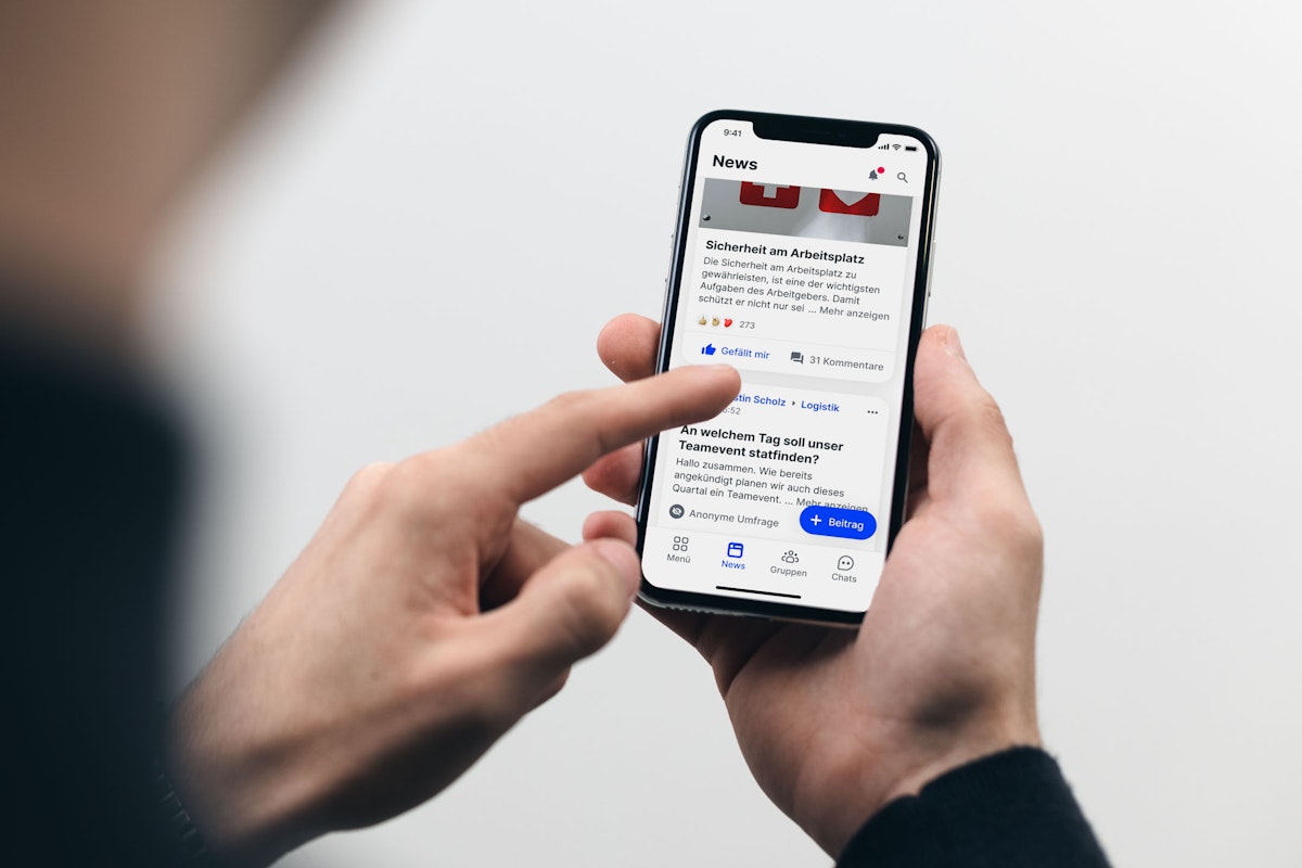 Person scrollt durch den Newsfeed auf dem Smartphone