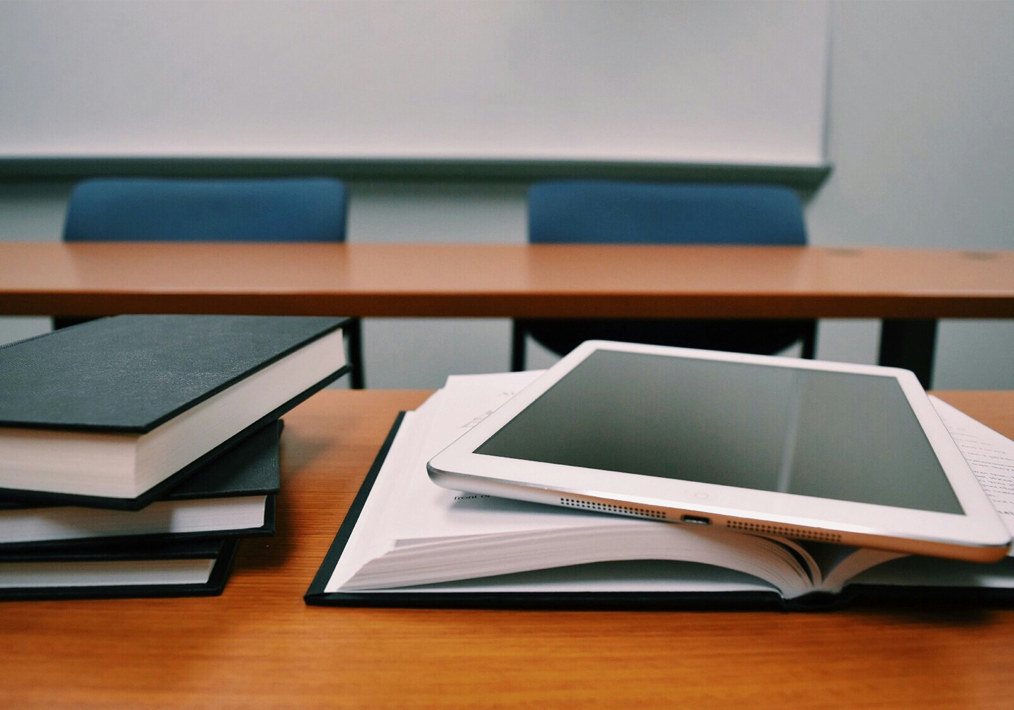 Tablet auf dem Tisch mit Büchern daneben