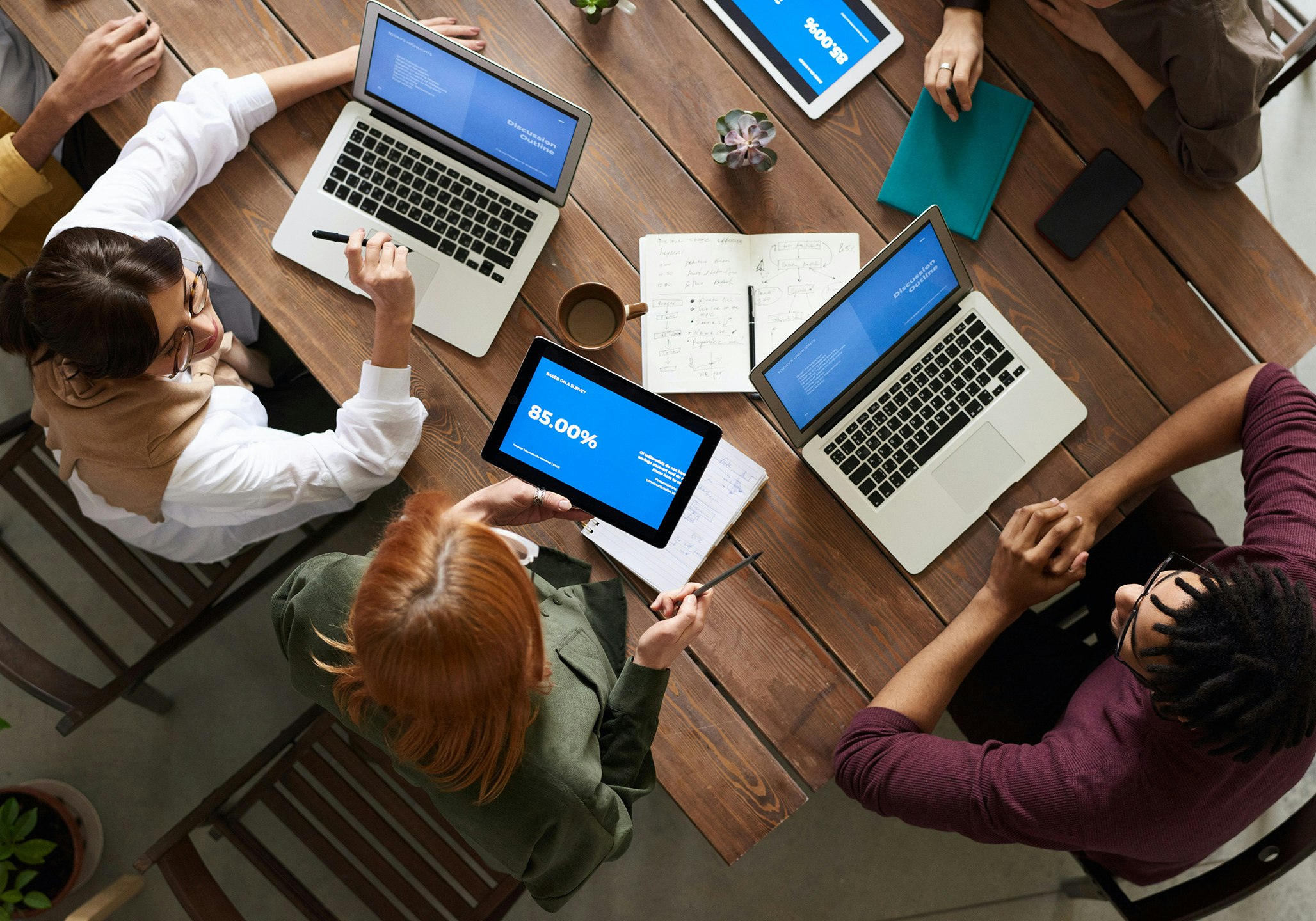 Personen mit Laptop und Tablet auf dem Tisch in Meeting