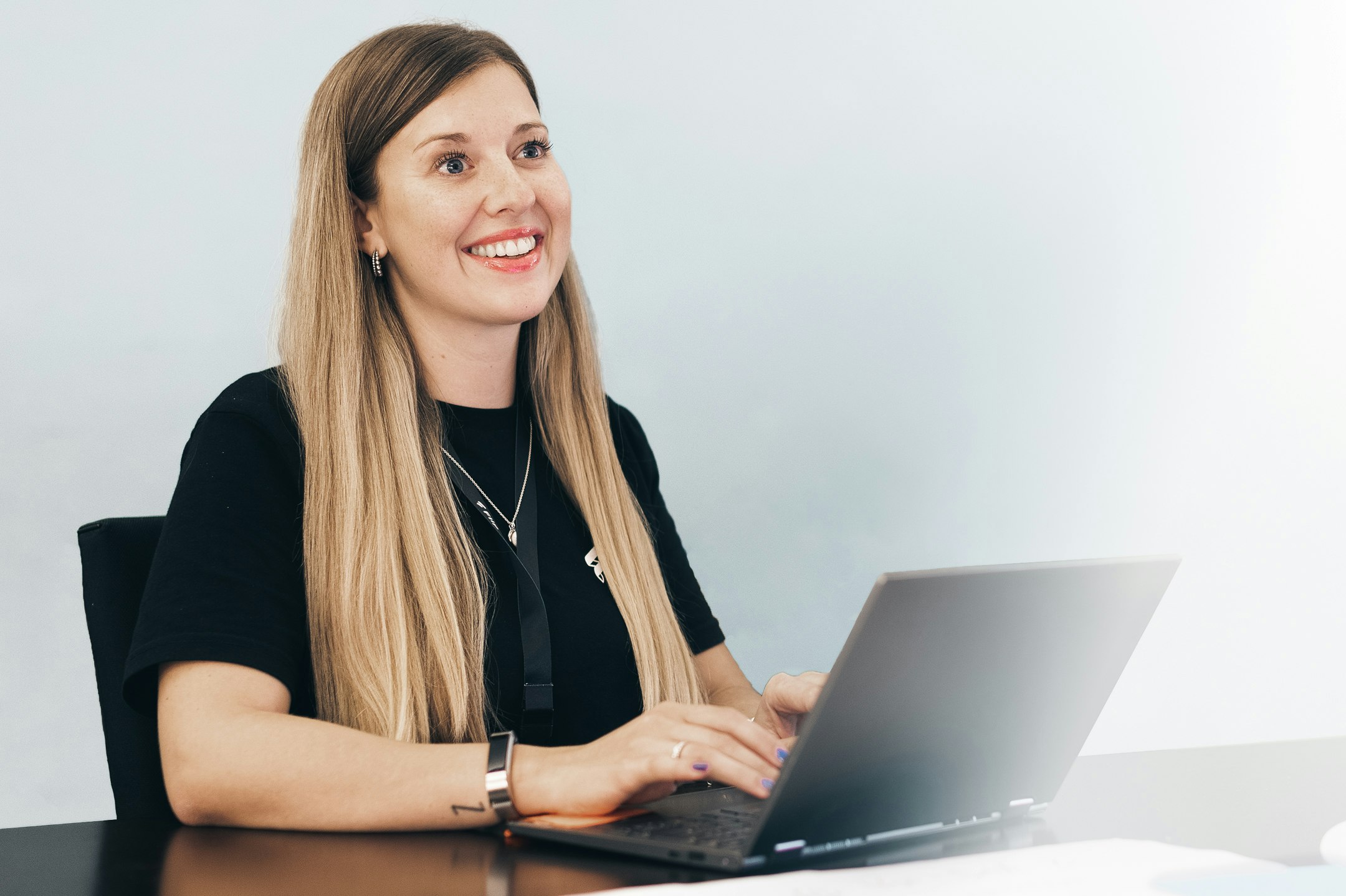 Lisa mit blonden Haaren und Flip-Shirt am Laptop