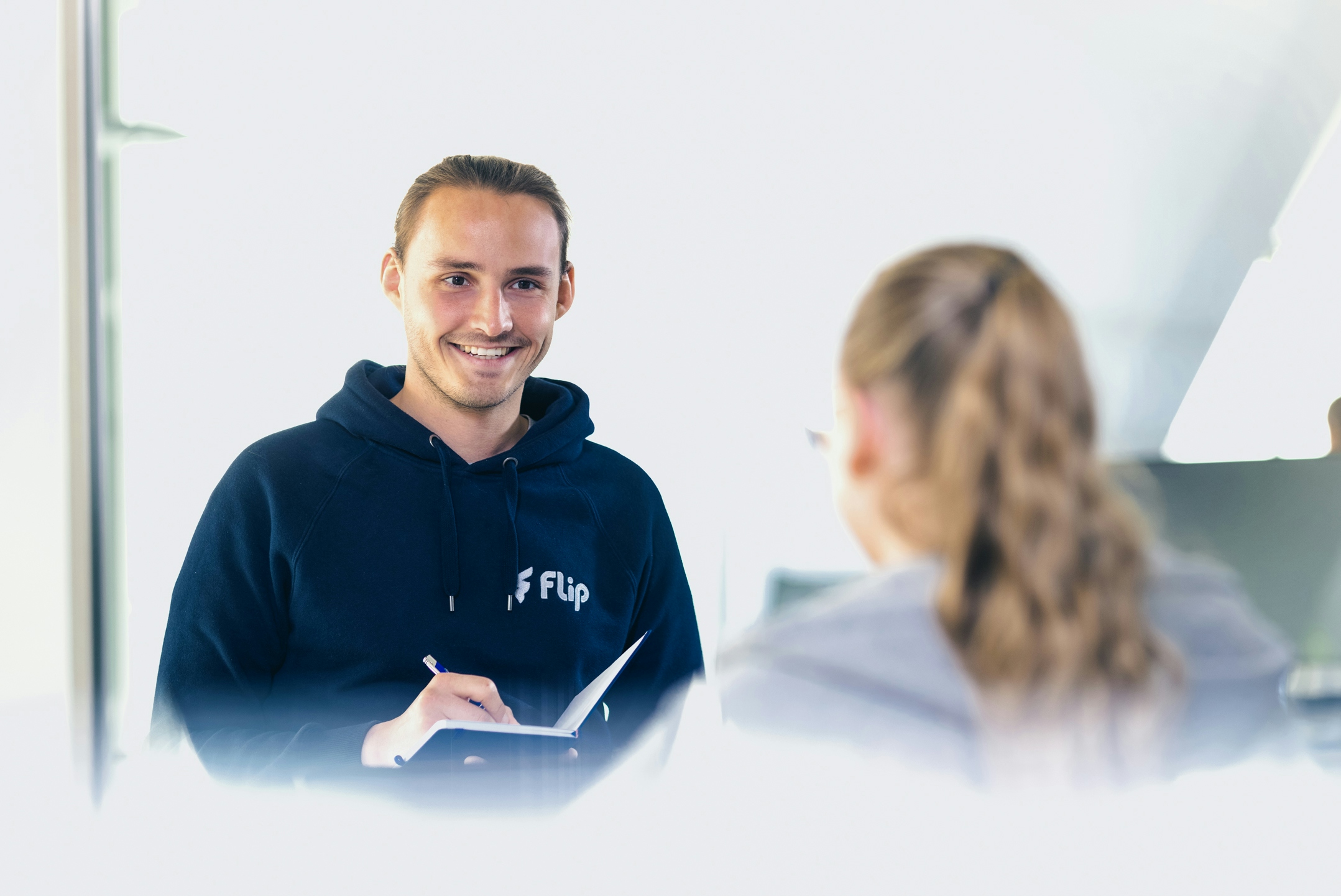 Mitarbeiter Tom macht Notizen im Gespräch