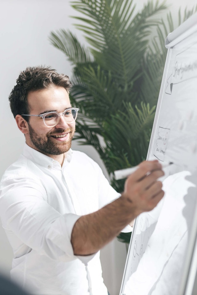 Patrik Kolligs, COO der Kronsteg GmbH, schreibt auf einem Whiteboard