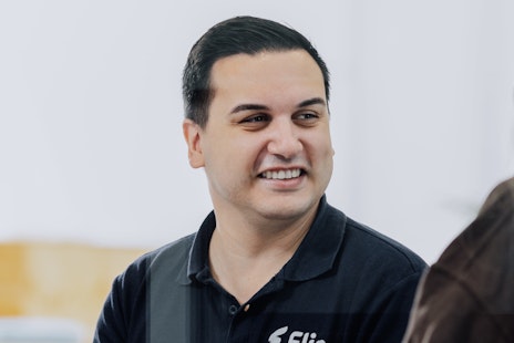 Mitarbeiter Tarek trägt Polo-Shirt mit Flip Logo