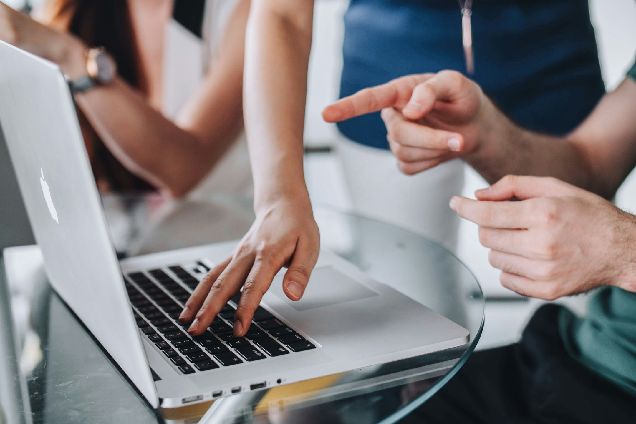 Hand tippt auf dem Keyword eines MacBooks