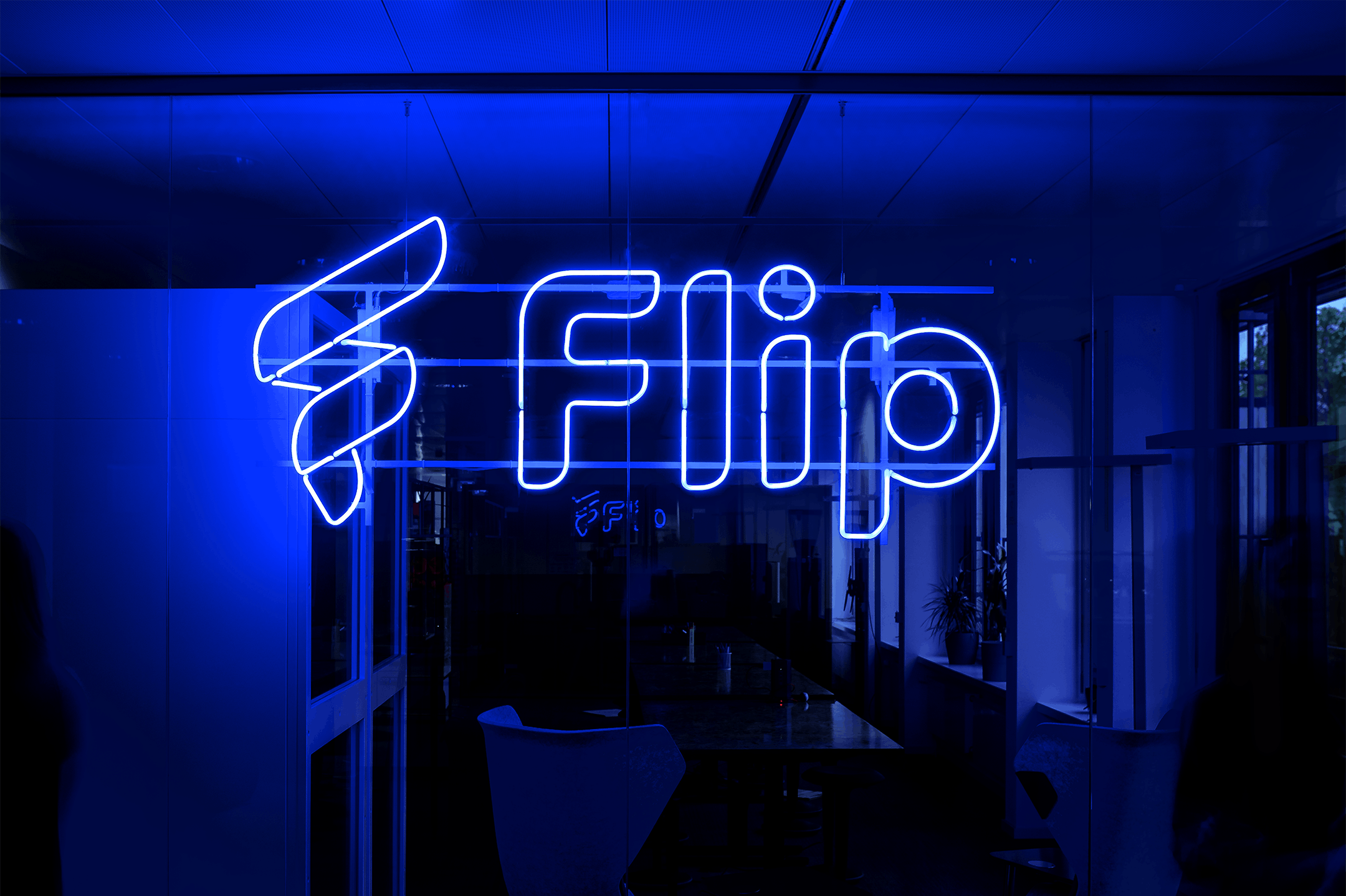 Blue neon sign showing the Flip logo