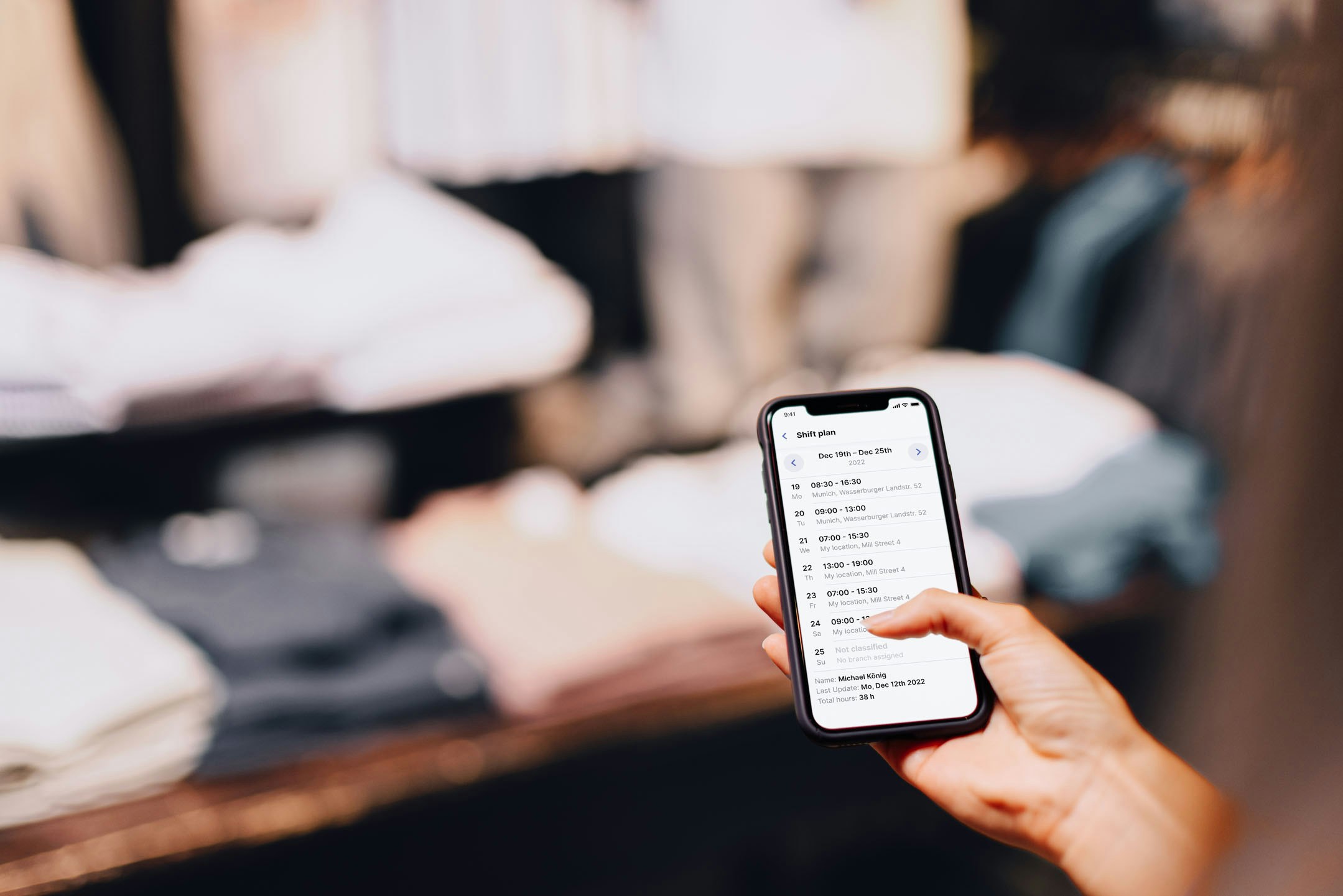 Smartphone with shift plan on display in front of clothes