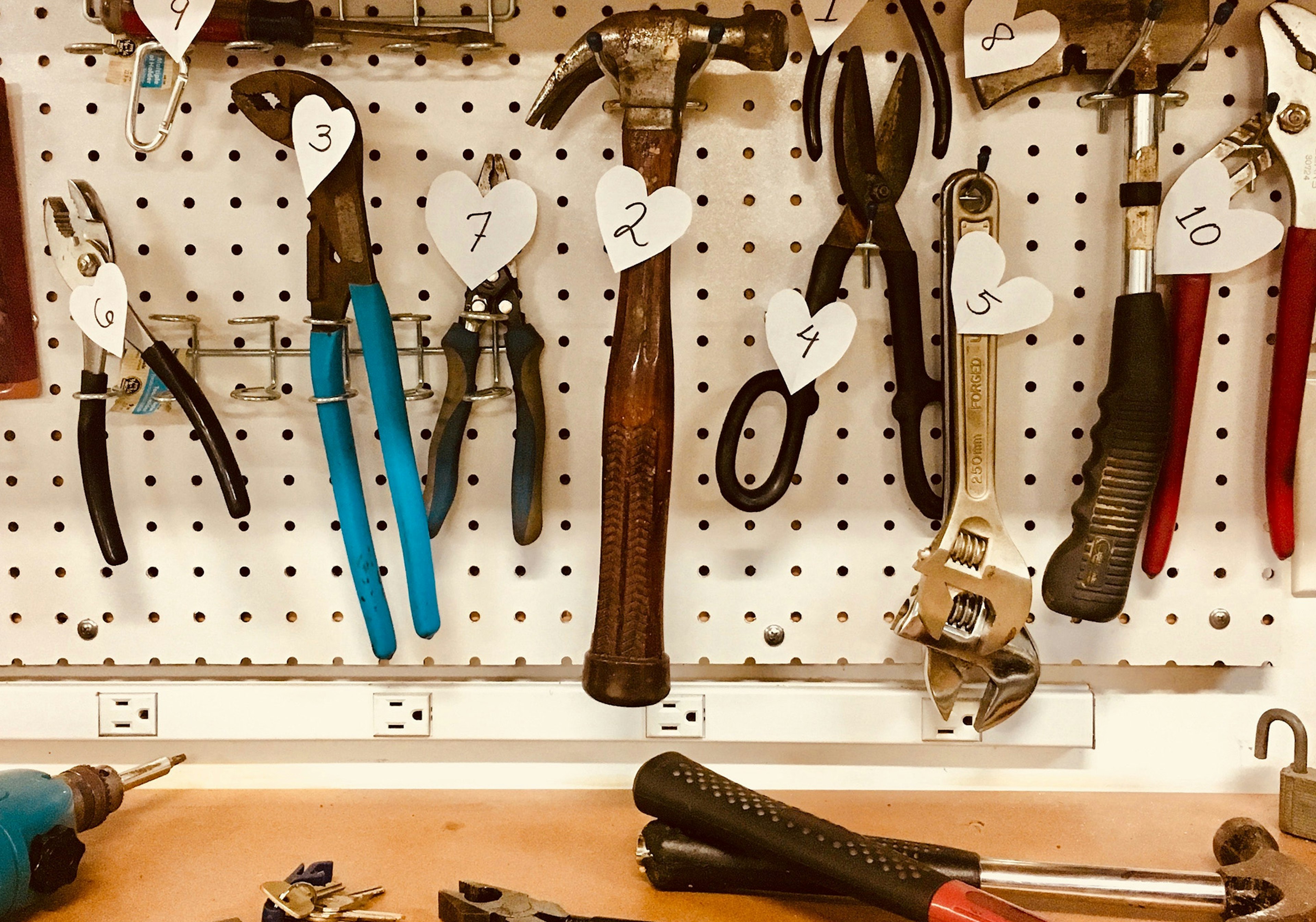 Werkzeuge hängen an Wand und liegen auf dem Tisch