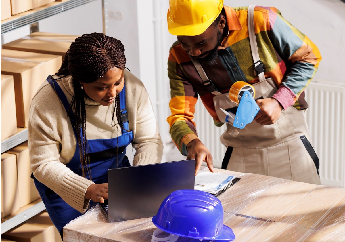 Two construction workers using a laptop