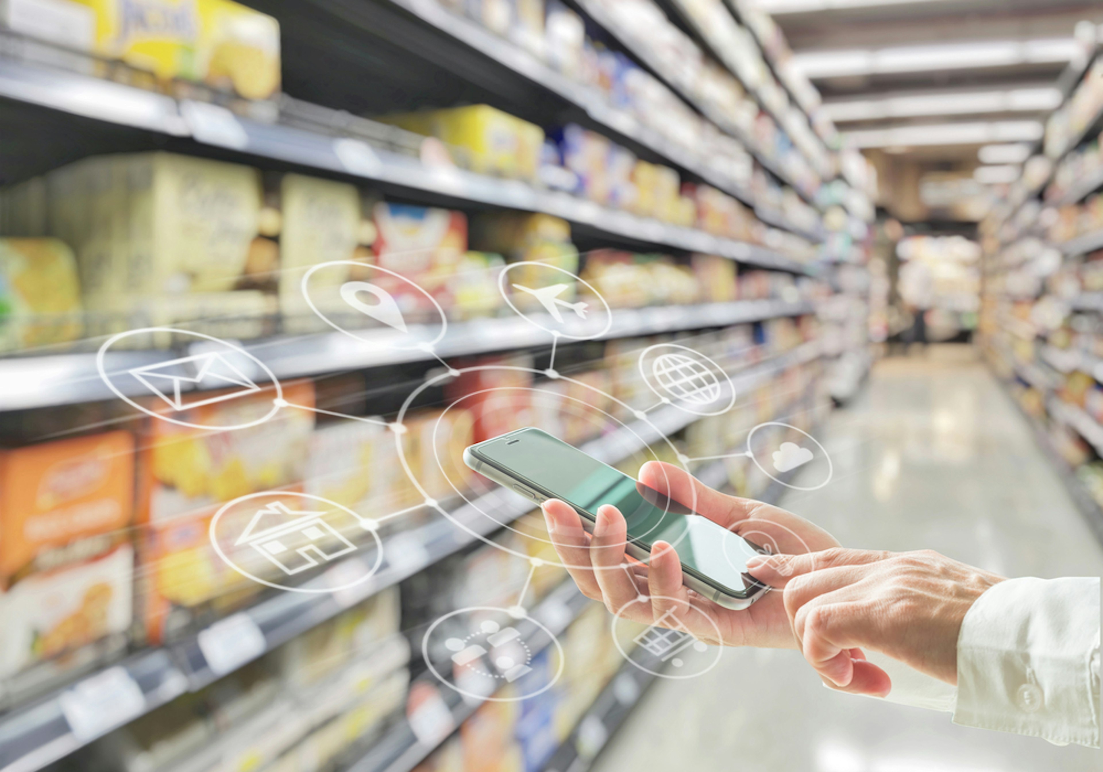 Smartphone mit visualisierten Funktionen zwischen Supermarktregalen.
