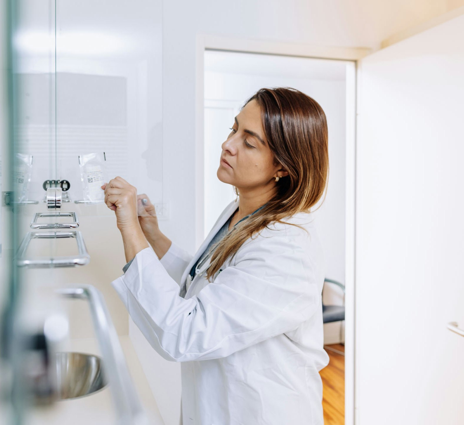 Doctor in white coat sorts bags into a cupboard