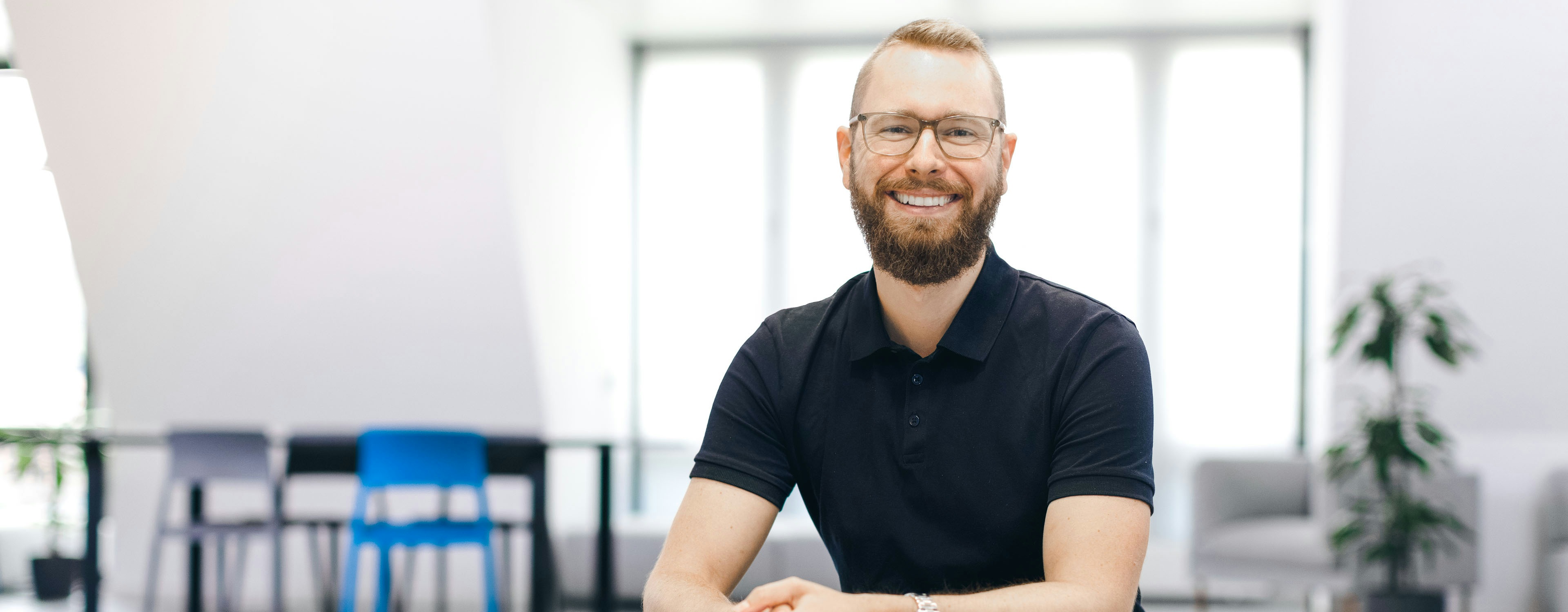 Giacomo Kenner sitzt lächelnd im Flip-Büro