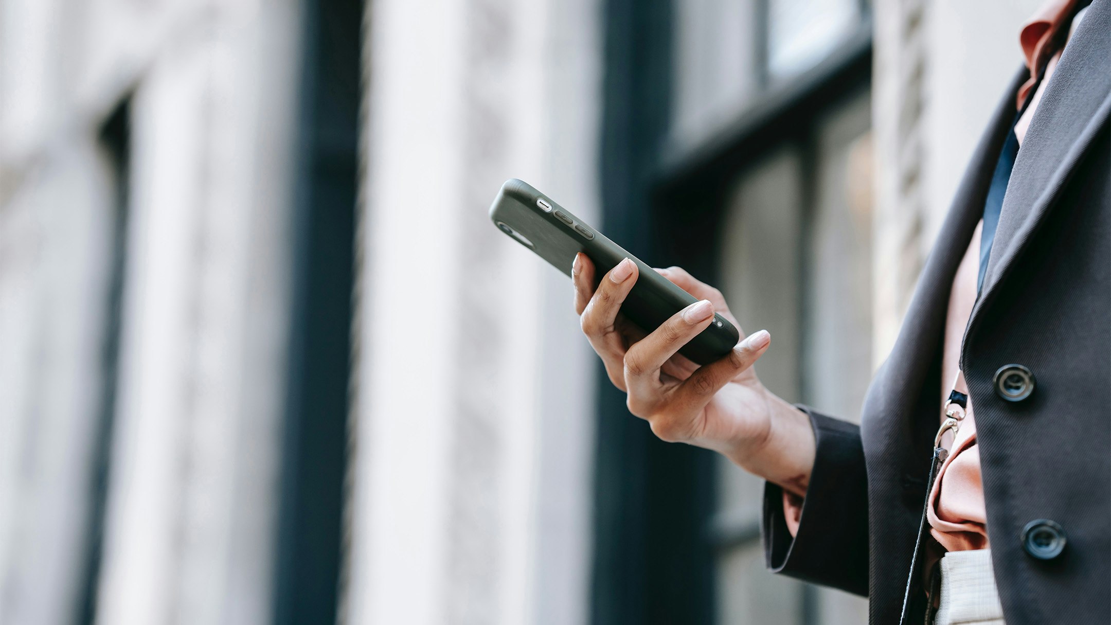 Hand einer Businessfrau mit Smartphone