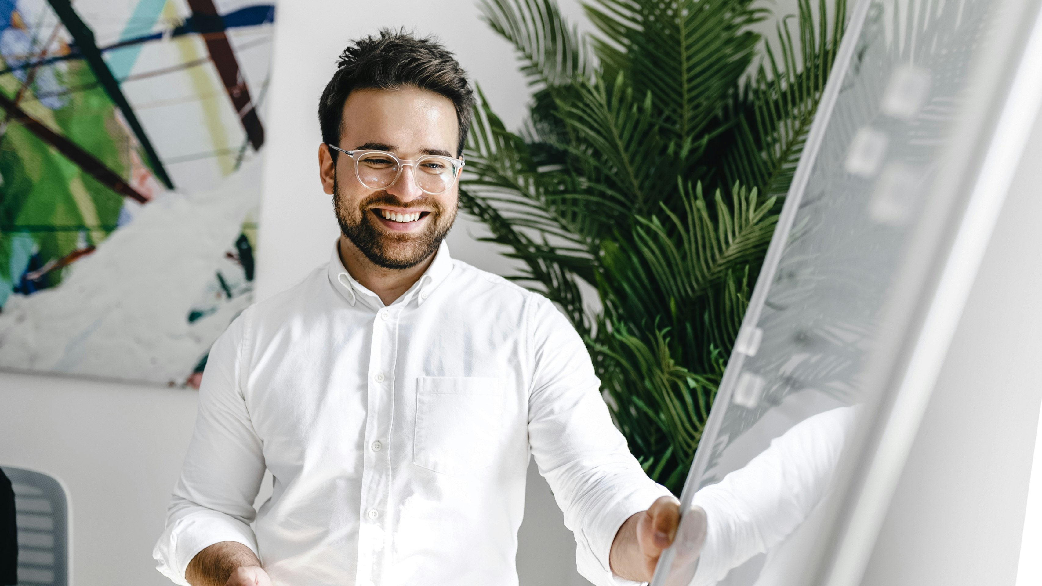 Patrick Kolligs, COO Kronsteg GmbH, in a withe shirt next to a whiteboard 