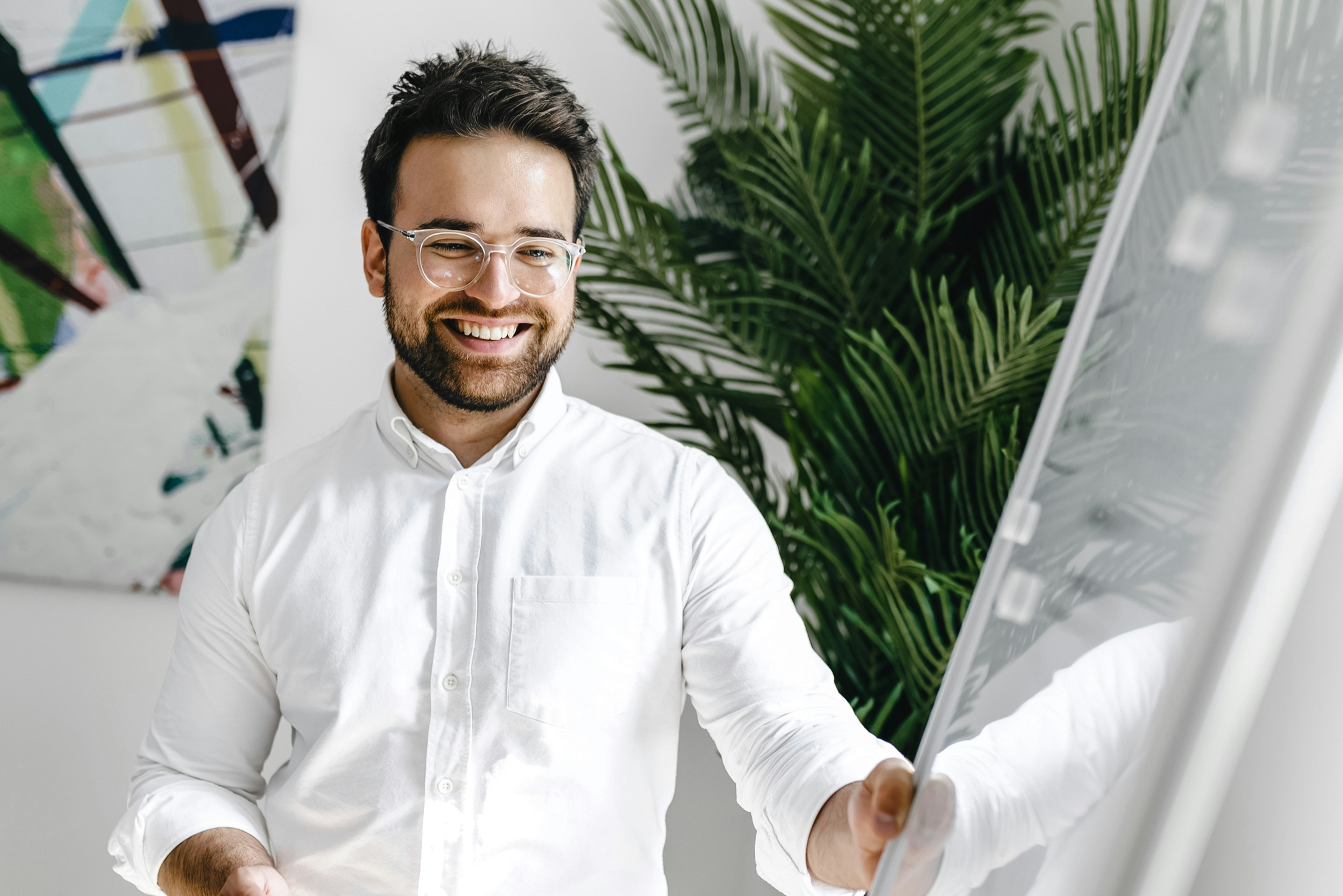 Patrick Kolligs, COO Kronsteg GmbH, in a withe shirt next to a whiteboard 