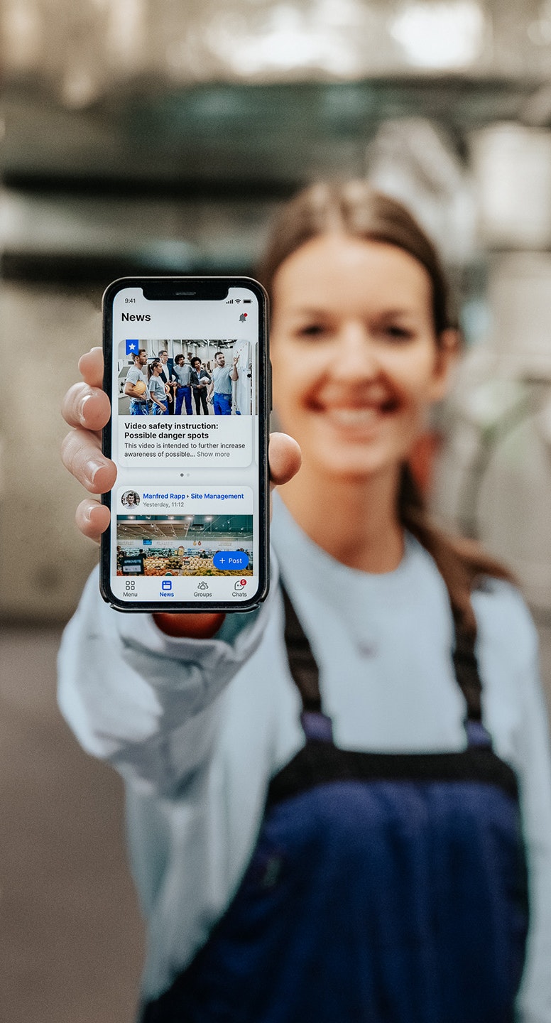 Woman is holding phone with Flip App and production site in background