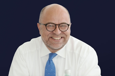 Stephan Rüschen is wearing a white shirt and a blue tie