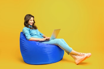 Woman sitting on a beanbag with a laptop