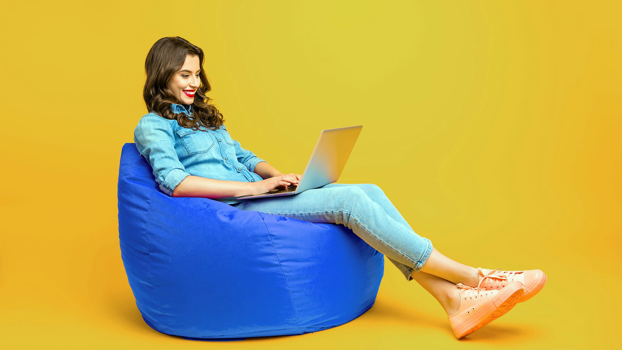 Woman sitting on a beanbag with a laptop