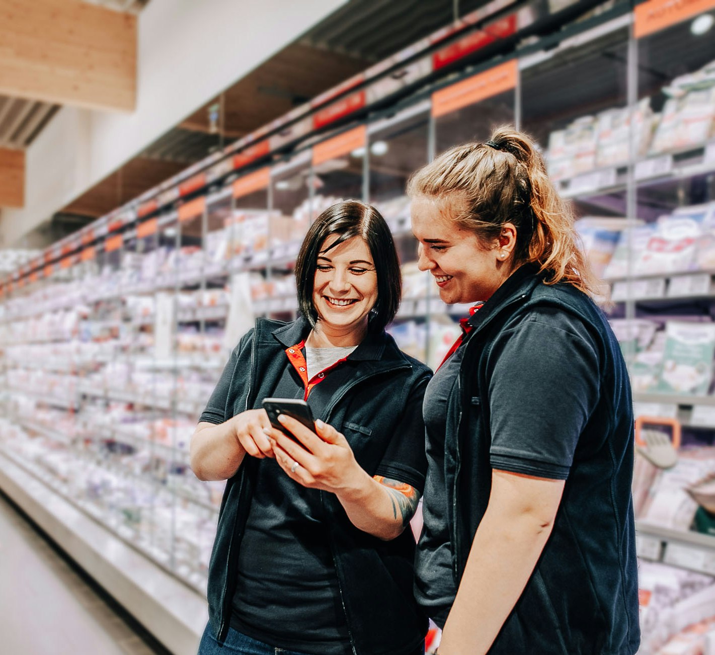 two female employees looking on a phone