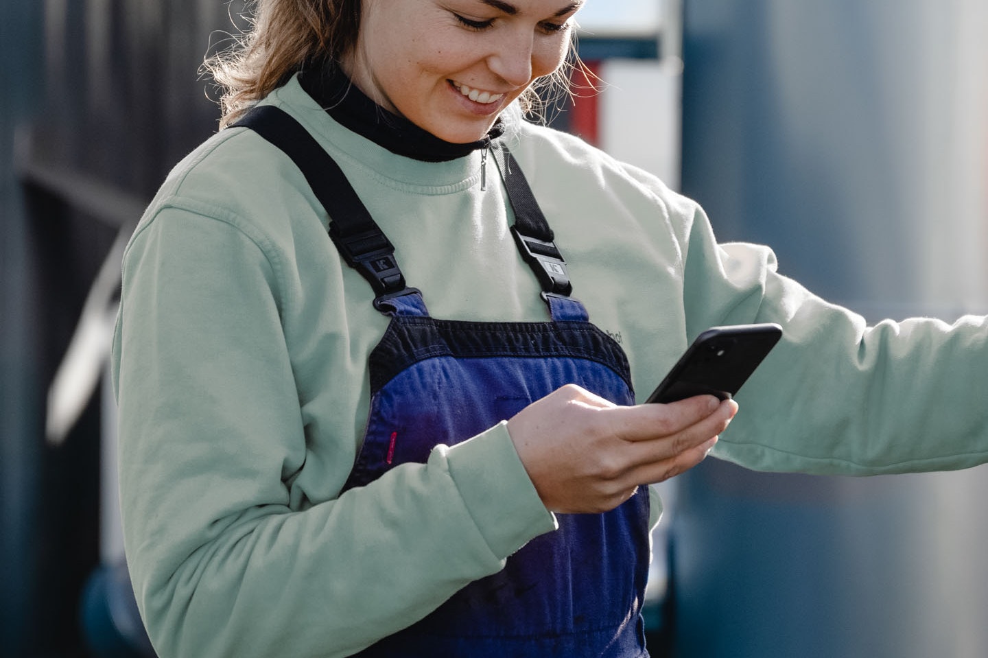 Brunette female maintenance worker in front of industrial plant