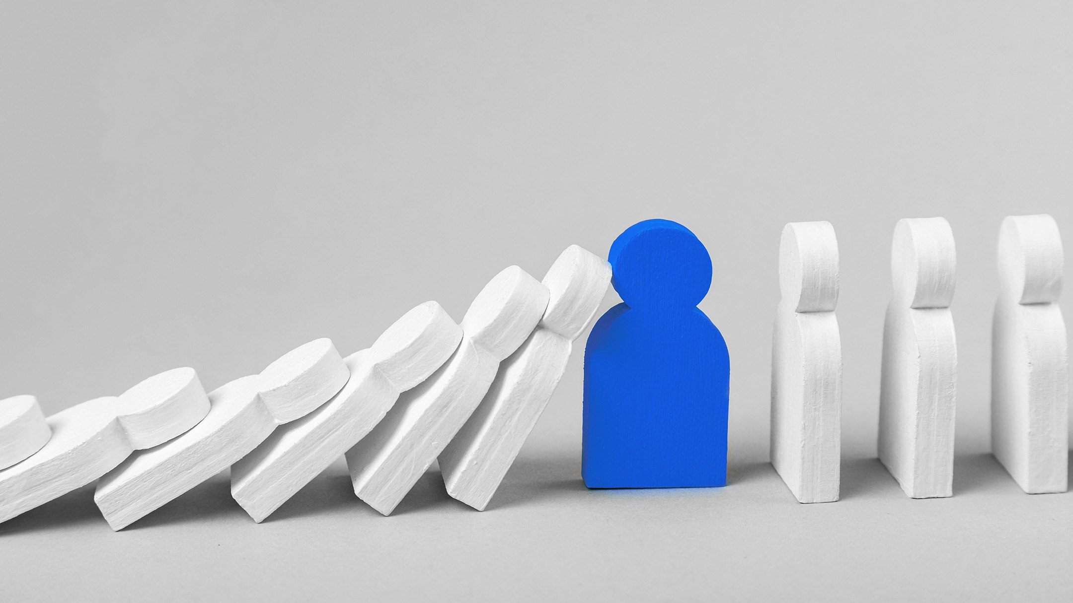 White wooden figures that fall over like dominoes