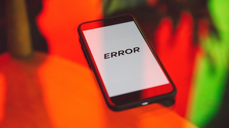 Smartphone auf Tisch zeigt auf Display das Wort ERROR an