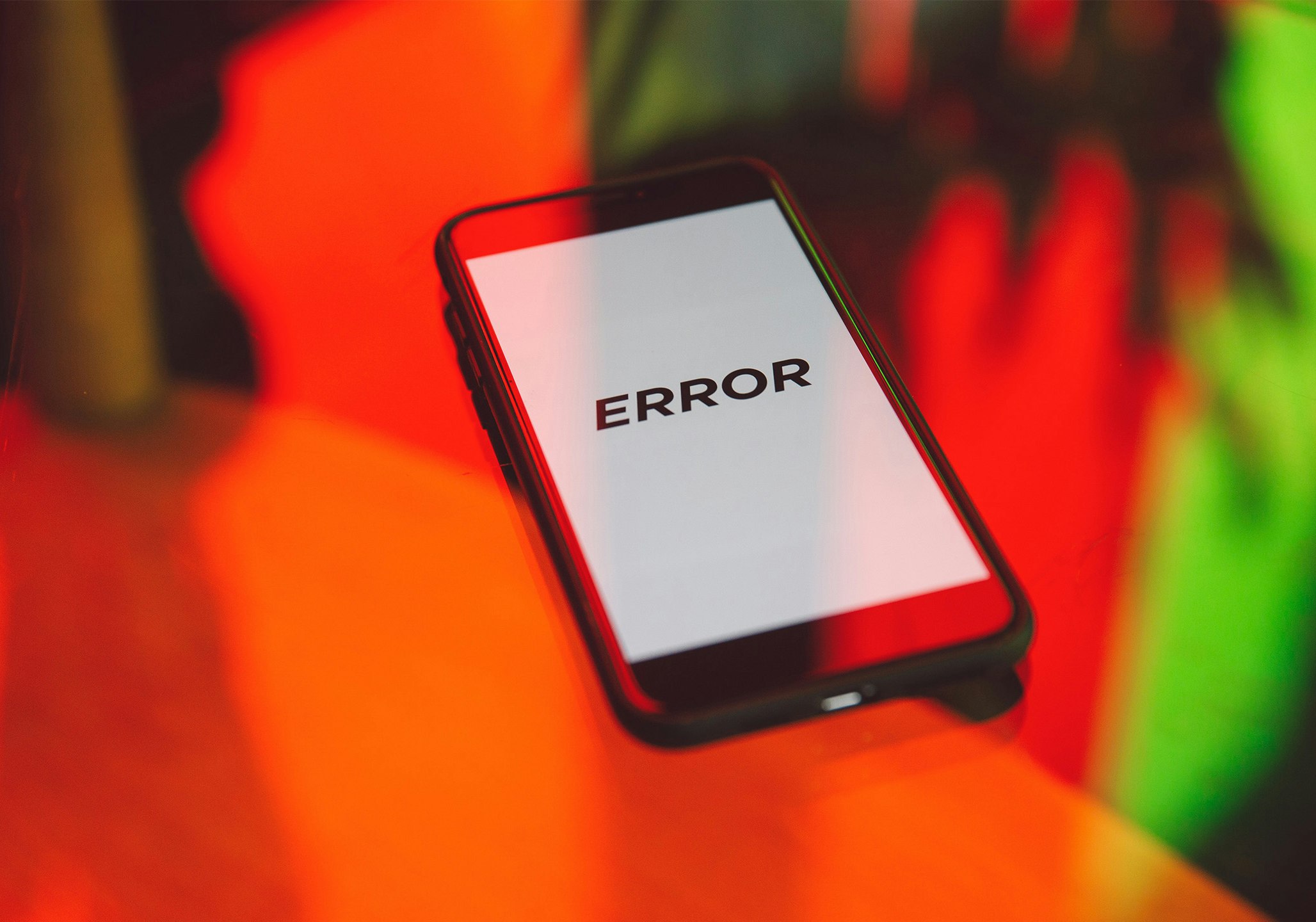 Smartphone auf Tisch zeigt auf Display das Wort ERROR an