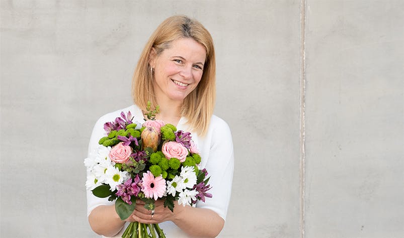 Person holding pink flower bouquet