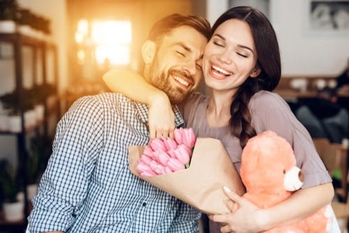 happy couple flowers and teddy