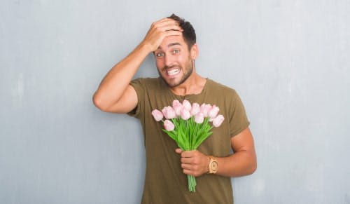 man holding flowers with look of horror