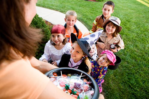 Mutter bietet Süßigkeiten an, Trick oder Treaters