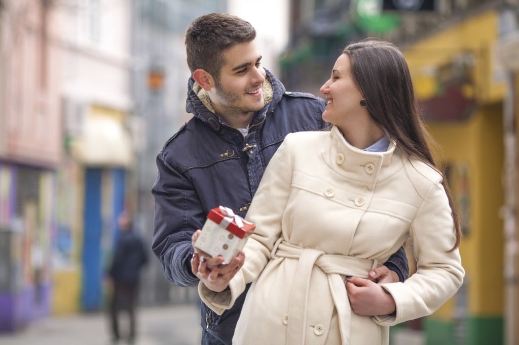 Happy young couple exchanging gifts on Valentine's Day.