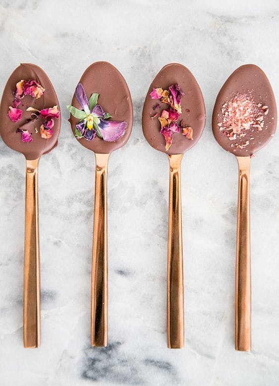 Cucharas bañadas en chocolate con pétalos de flores comestibles de colores