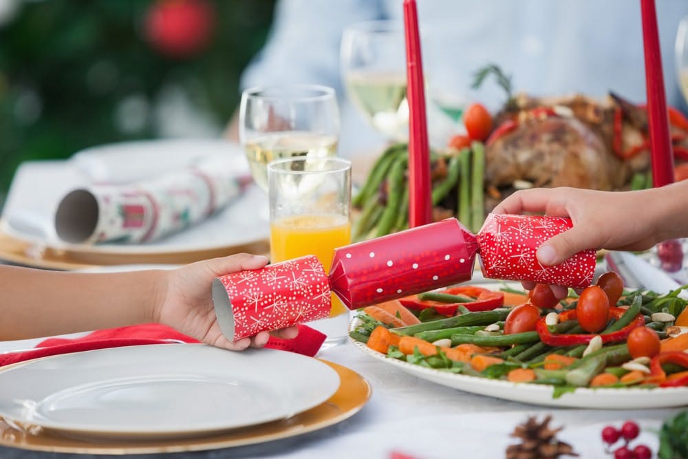 Crackers de Navidad en una mesa navideña llena de comida