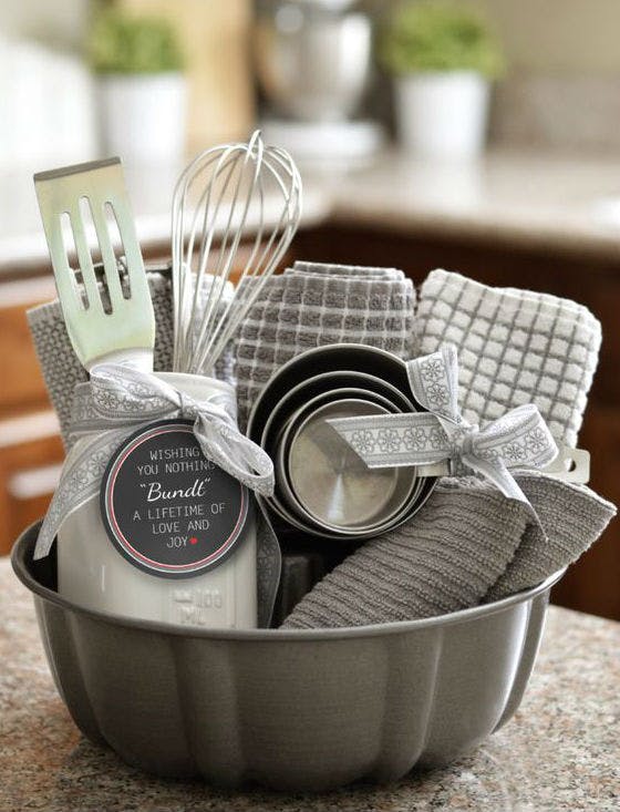 Cesta de molde de pastel con utensilios de cocina, paños y moldes de galletas