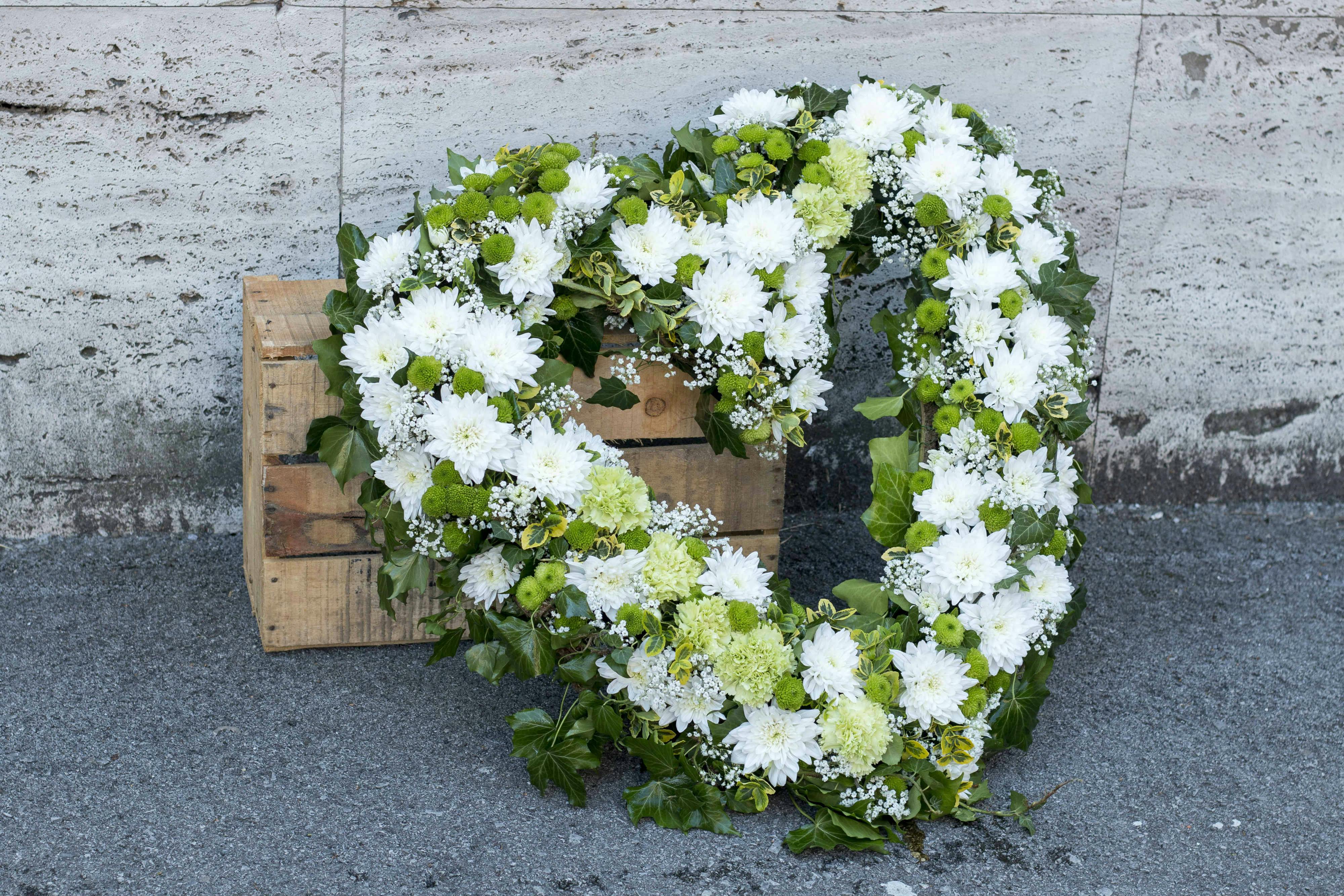 Corona funeraria en forma de corazón con flores blancas