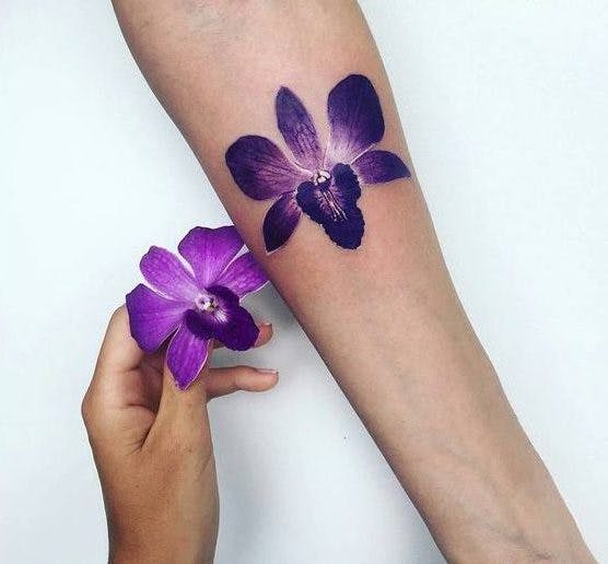 Tatuaje de orquídea morada en un brazo