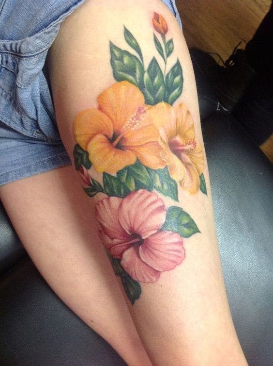 Tatuaje de tres flores de hibiscus en una pierna