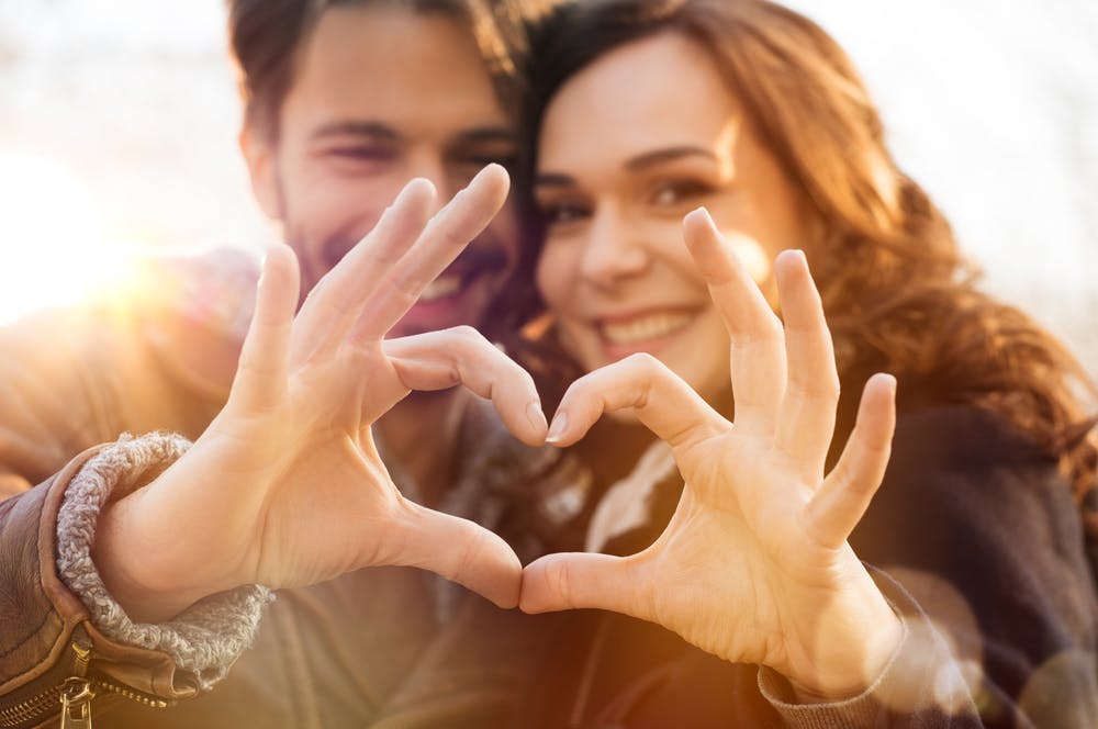 Pareja corazón dedos