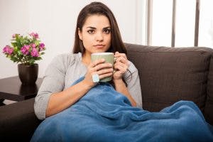 jeune femme avec une tasse et une couverture