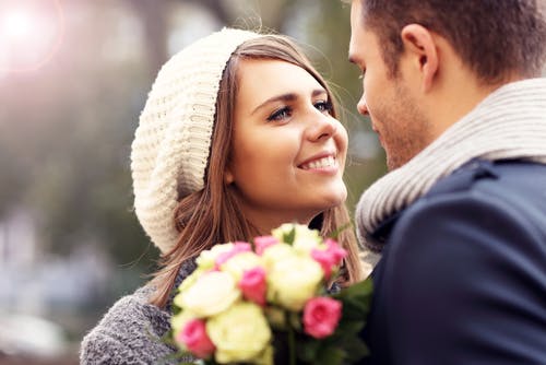 Happy couple bouquet of flowers smiling girl