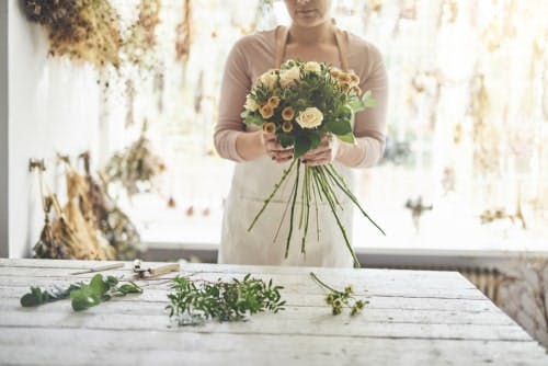 unseen florist arranging flowers