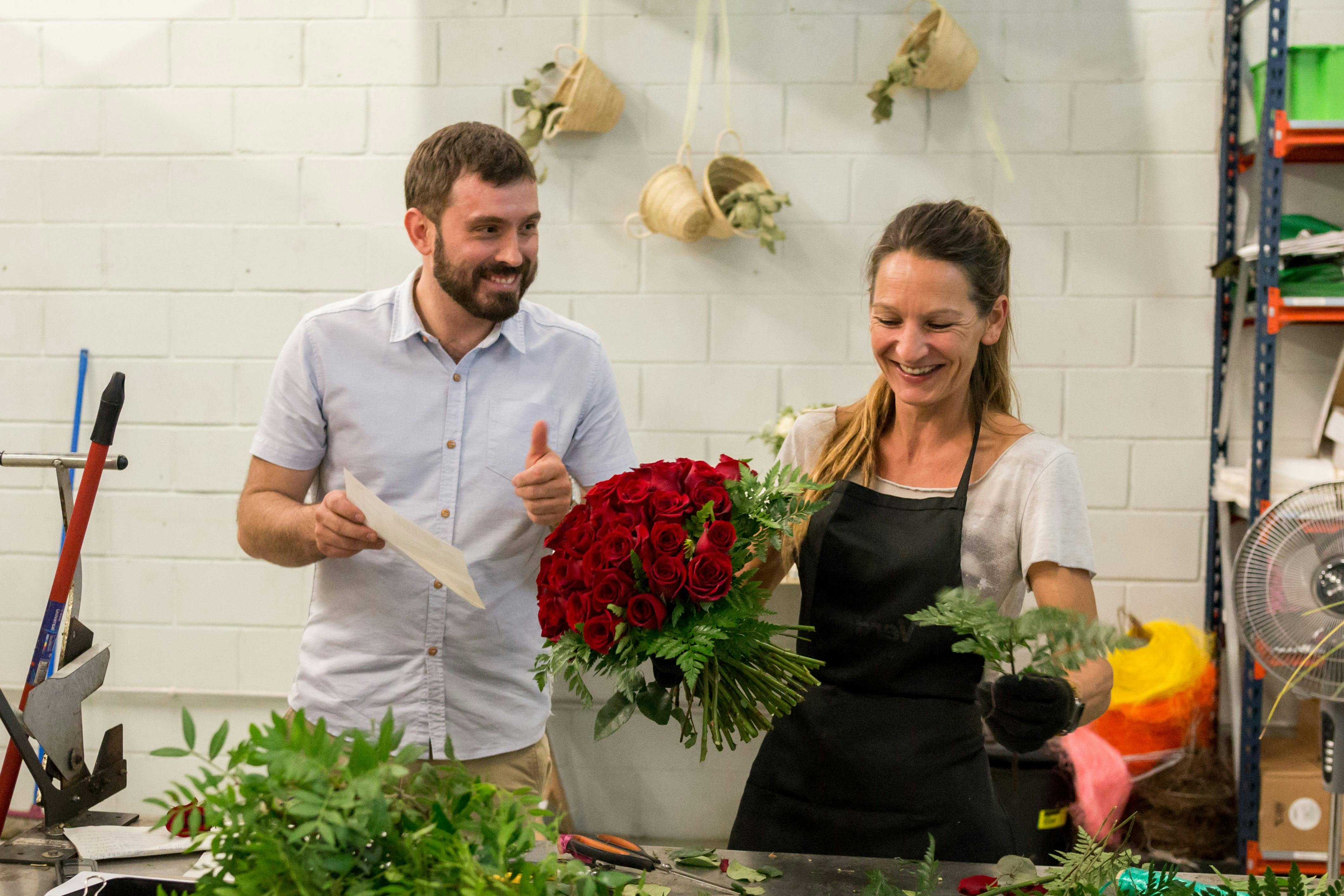 Aureli working on a fresh bouquet of red roses