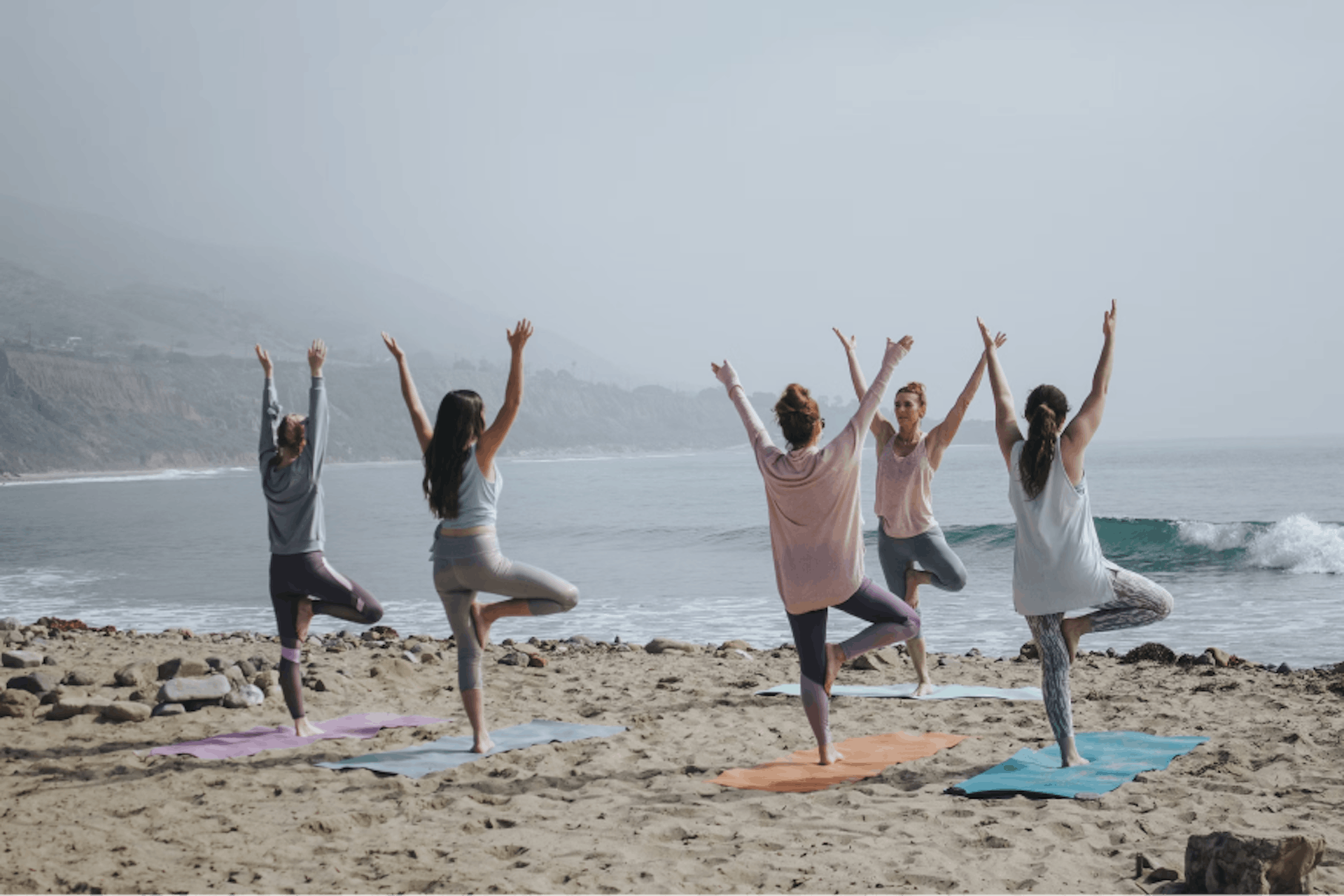 Group of people doing yoga in the beach