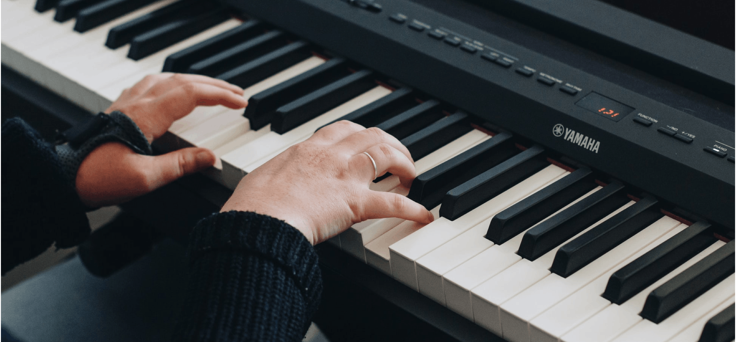Two hands playing on a Yamaha keyboard
