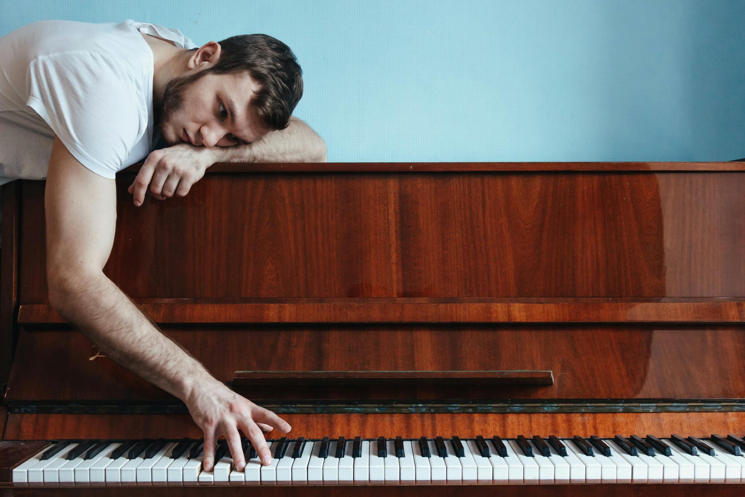 man lying on a piano