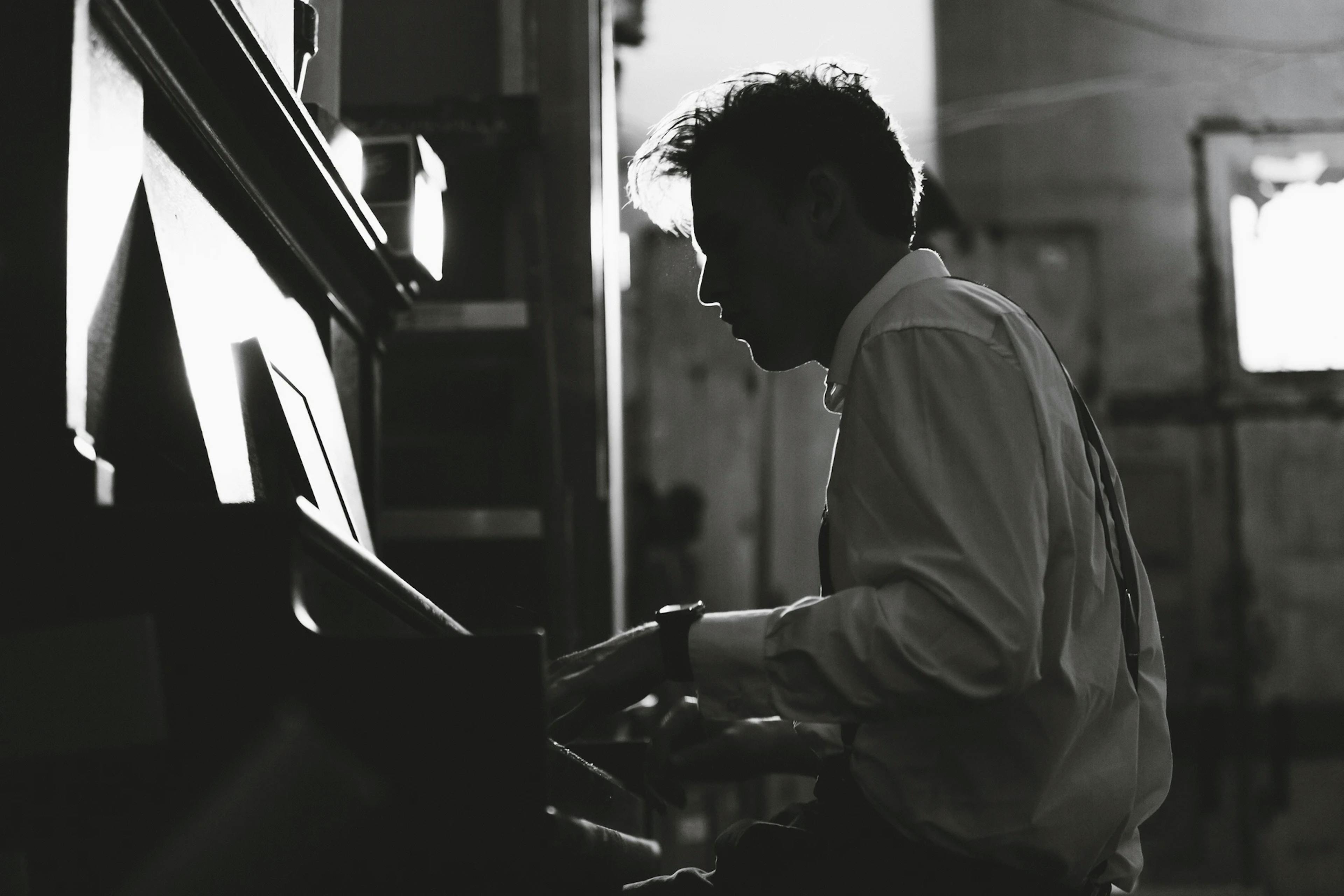 Mann im weißen Hemd am Klavier